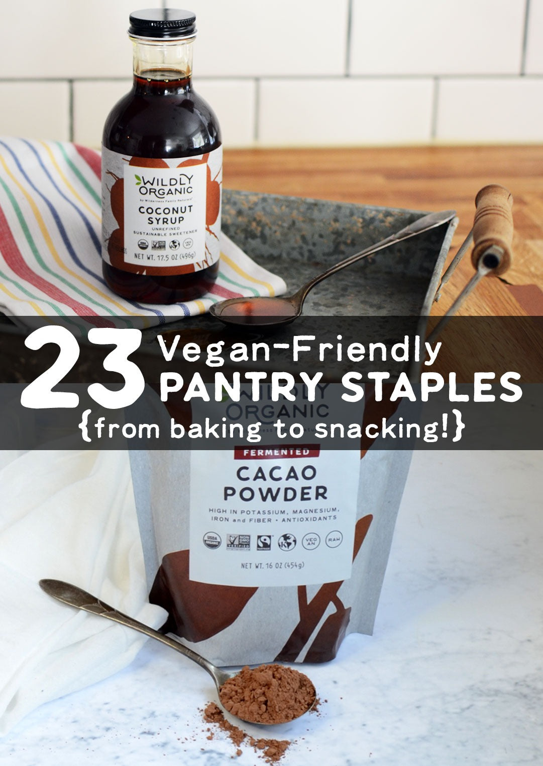 Coconut syrup bottle, cacao powder bag, and spoon with text 23 Vegan-Friendly PANTRY STAPLES from baking to snacking
