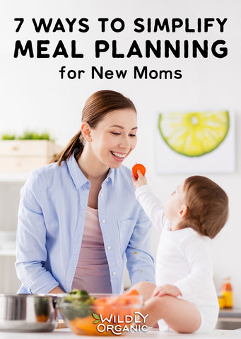 Mom and toddler eating veggies in the kitchen, simplifying meal planning for new moms with easy, healthy recipes