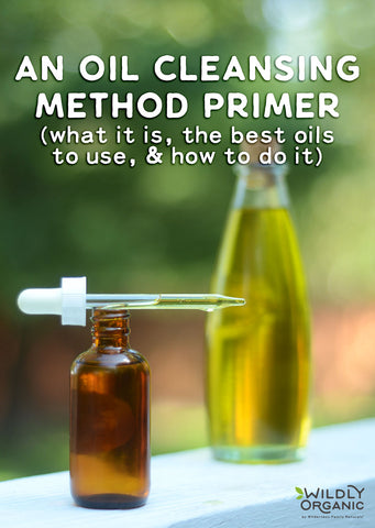 Dropper bottle with oil and a larger oil bottle in the background with text about oil cleansing