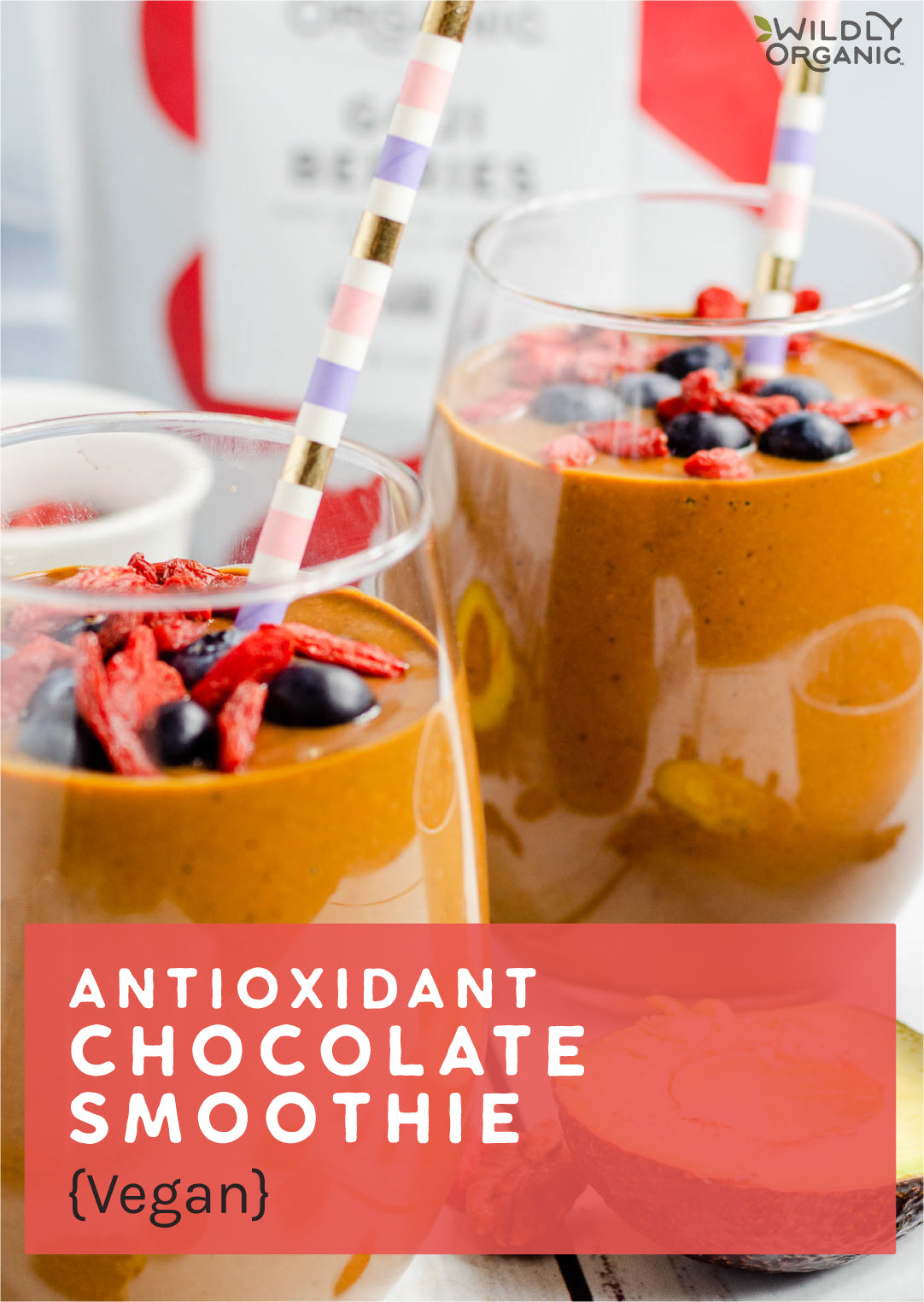 Antioxidant chocolate smoothie with goji berries and blueberries in a glass with a striped straw, labeled vegan