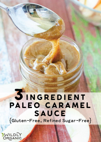 A jar with nut butter paleo caramel sauce with a spoon dipping into it.