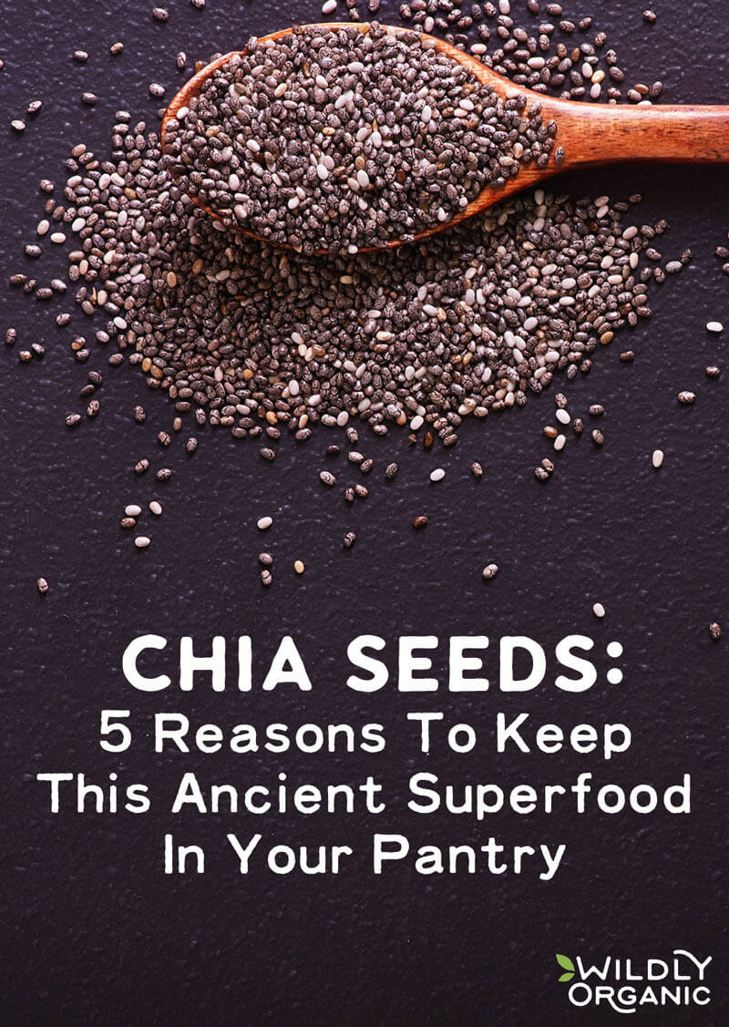 A wooden spoon overflowing with chia seeds on a dark surface with text CHIA SEEDS: 5 Reasons To Keep This Ancient Superfood In Your Pantry