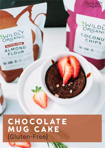 chocolate cake in a cup on a saucer with strawberries on top. Wildly Organic packaging in the background