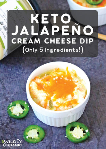 A ramekin of keto jalapeño cream cheese dip topped with shredded cheddar cheese and slices of jalapeño.