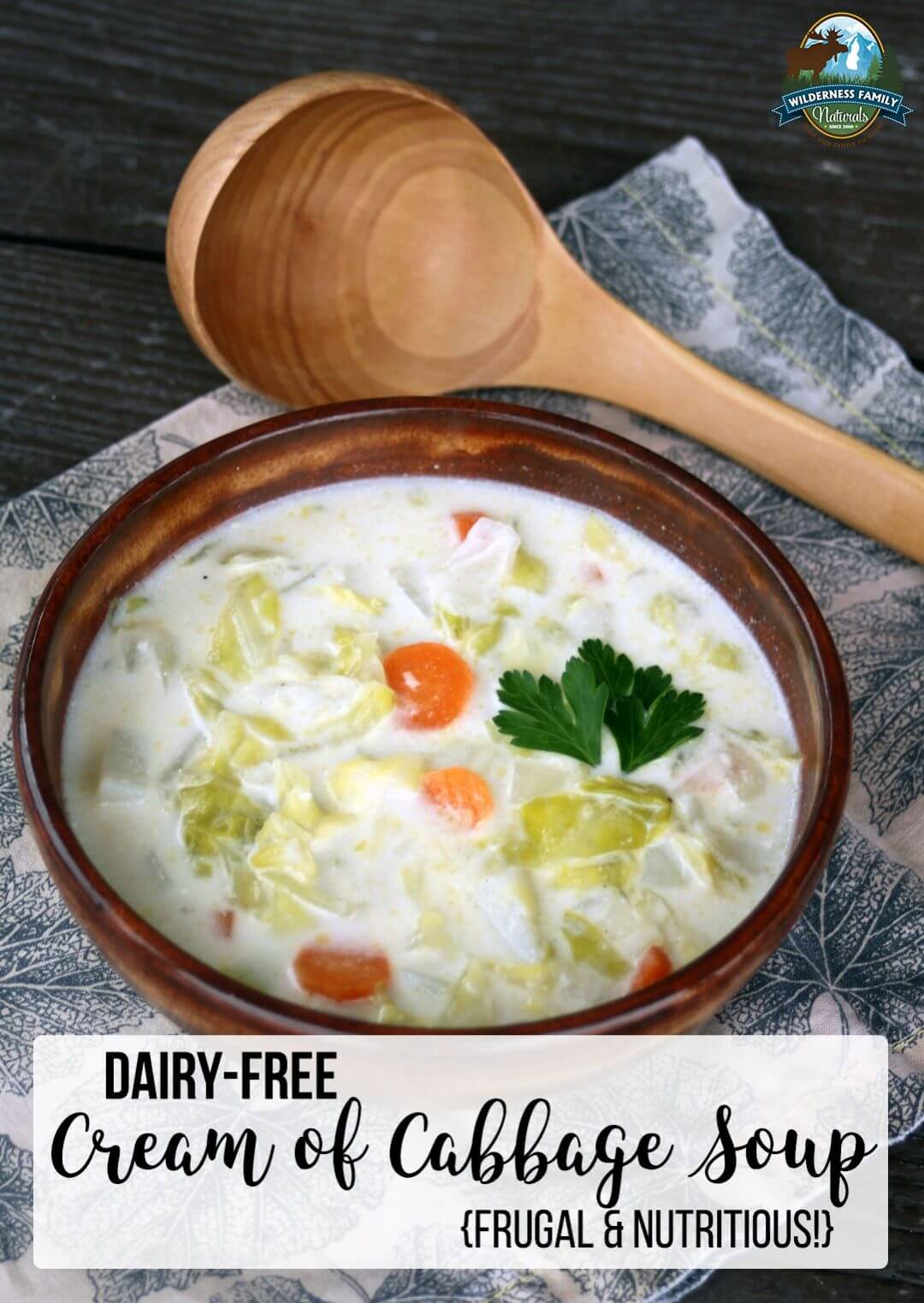 Bowl of dairy-free cream of cabbage soup garnished with parsley, with a wooden spoon.