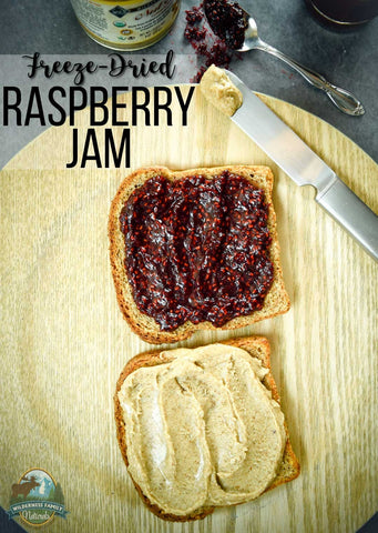 Two slices of bread on a wooden board; one with raspberry jam, one with peanut butter. Text Freeze-Dried RASPBERRY JAM above.