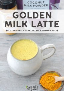 Photo of golden milk latte in a ceramic mug with a dish of turmeric next to it.