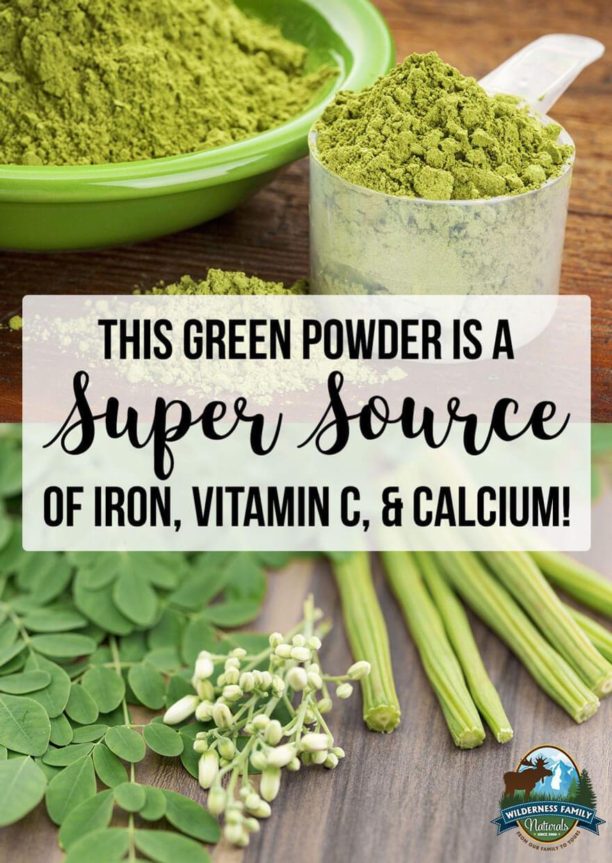 Green powder in a scoop, advertised as rich in iron, vitamin C, and calcium, with moringa leaves and pods