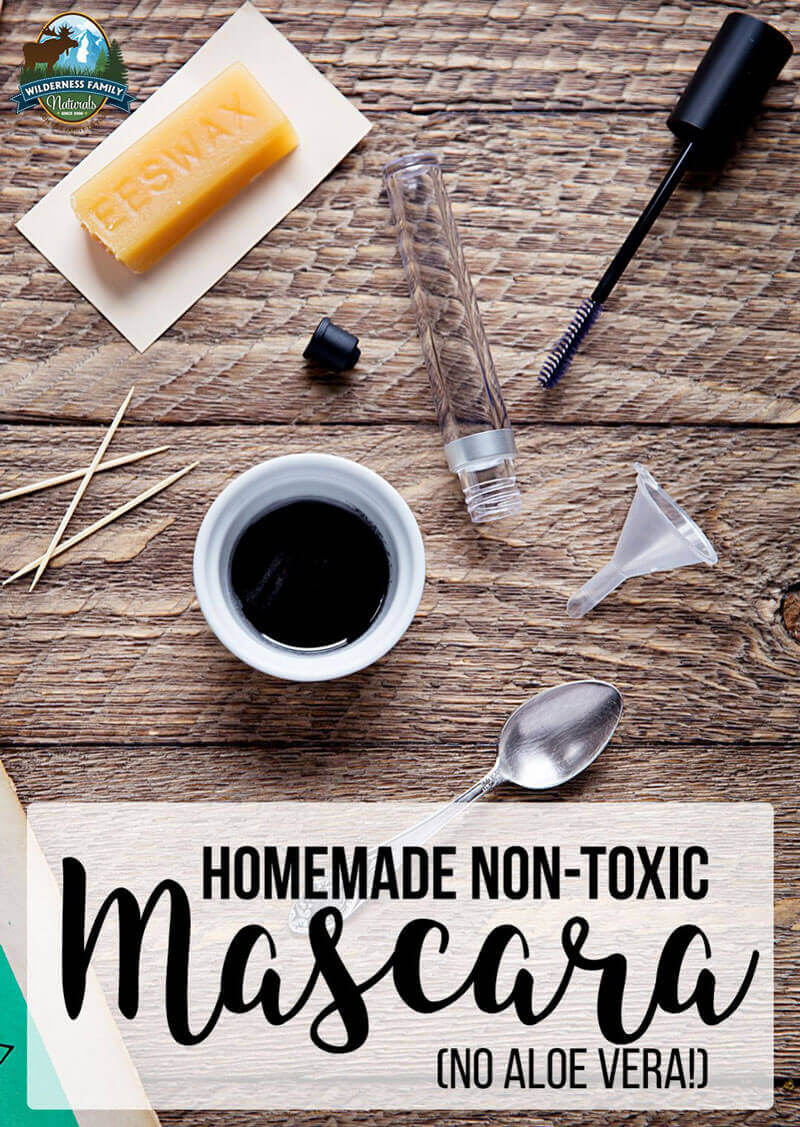 Ingredients for homemade non-toxic mascara without aloe vera, including beeswax empty tube small funnel and black liquid