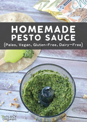A food processor with spinach basil homemade pesto sauce in it scattered with Wildly Organic Walnuts.