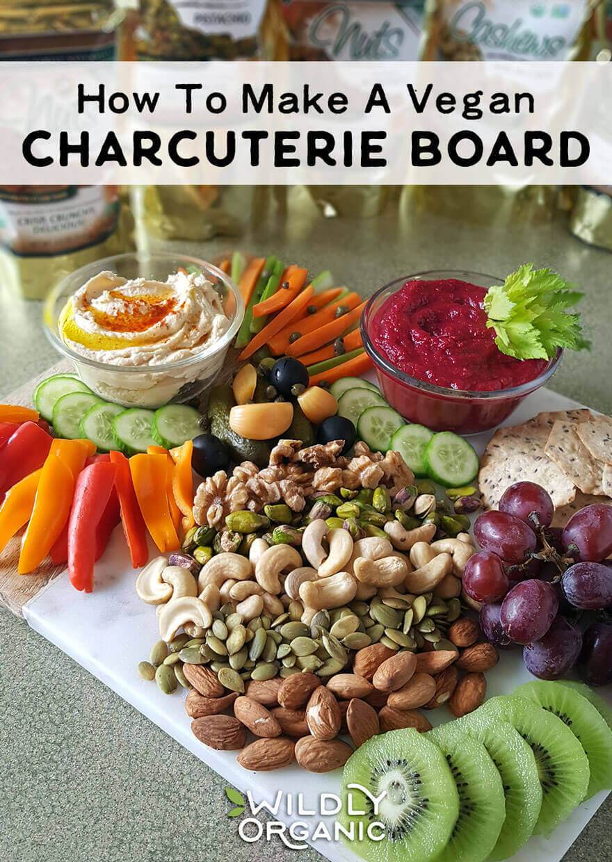 Photo of a vegan charcuterie board with veggies, nuts, dips, crackers, and fruit, perfect for parties or snack time