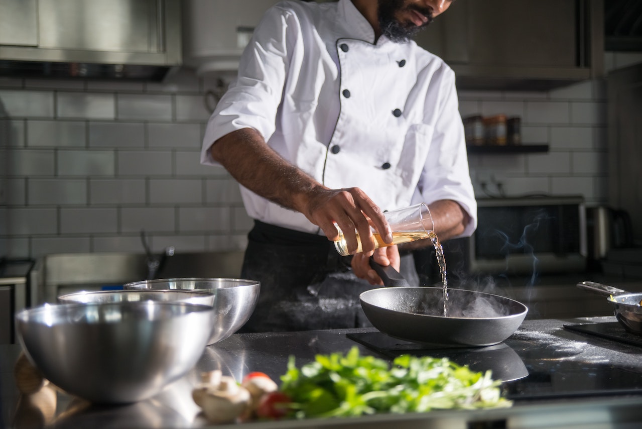 A man pouring palm oil into a pan