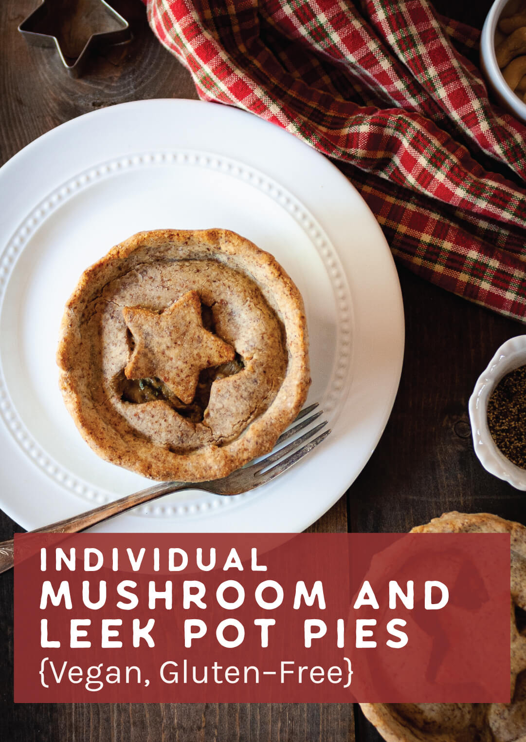 Individual Mushroom and Leek Pot Pie on a white plate on a wooden table with a plaid napkin, star cookie cutter, and metal fork.