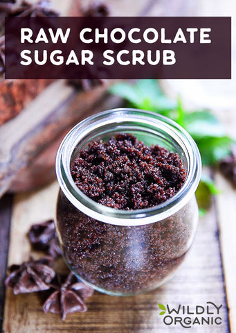 A jar of raw chocolate sugar scrub on a wooden surface with star anise pods around