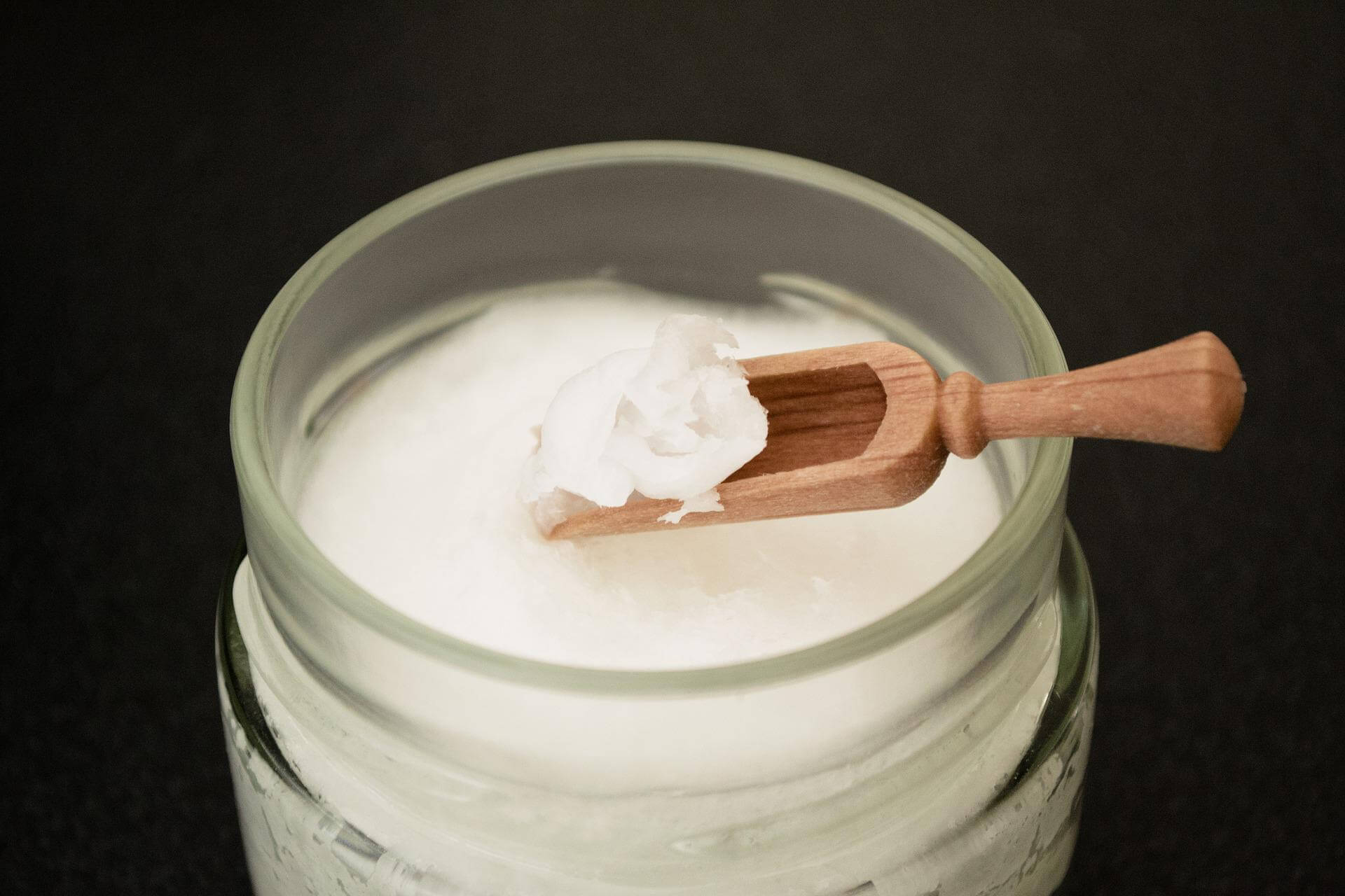 solid coconut oil with wooden scoop