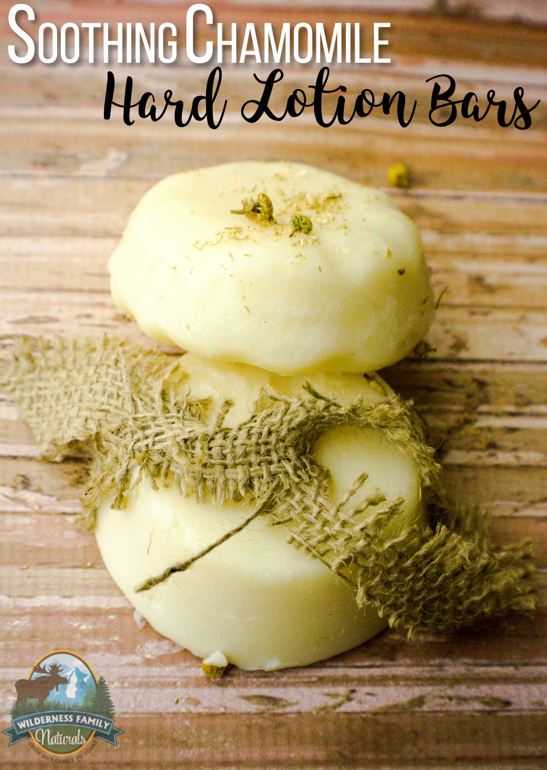 Three chamomile hard lotion bars with a burlap ribbon on a wooden surface