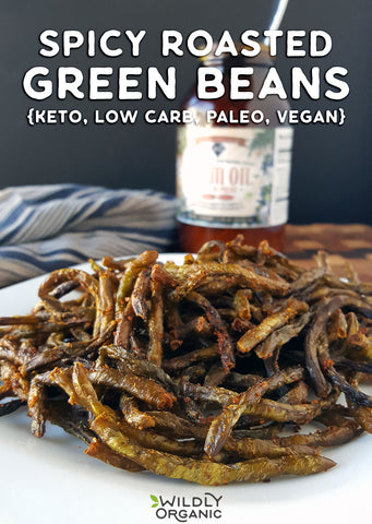 Photo of spicy roasted green beans on a plate with cooking oil in the background.