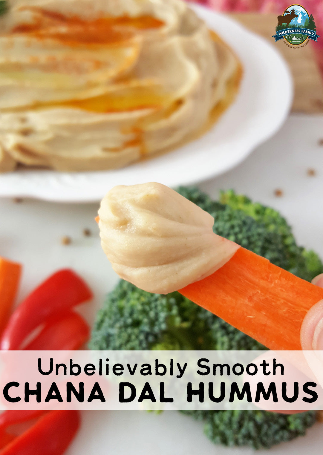 A carrot dipped in smooth chana dal hummus with veggies and text overlay: Unbelievably Smooth CHANA DAL HUMMUS