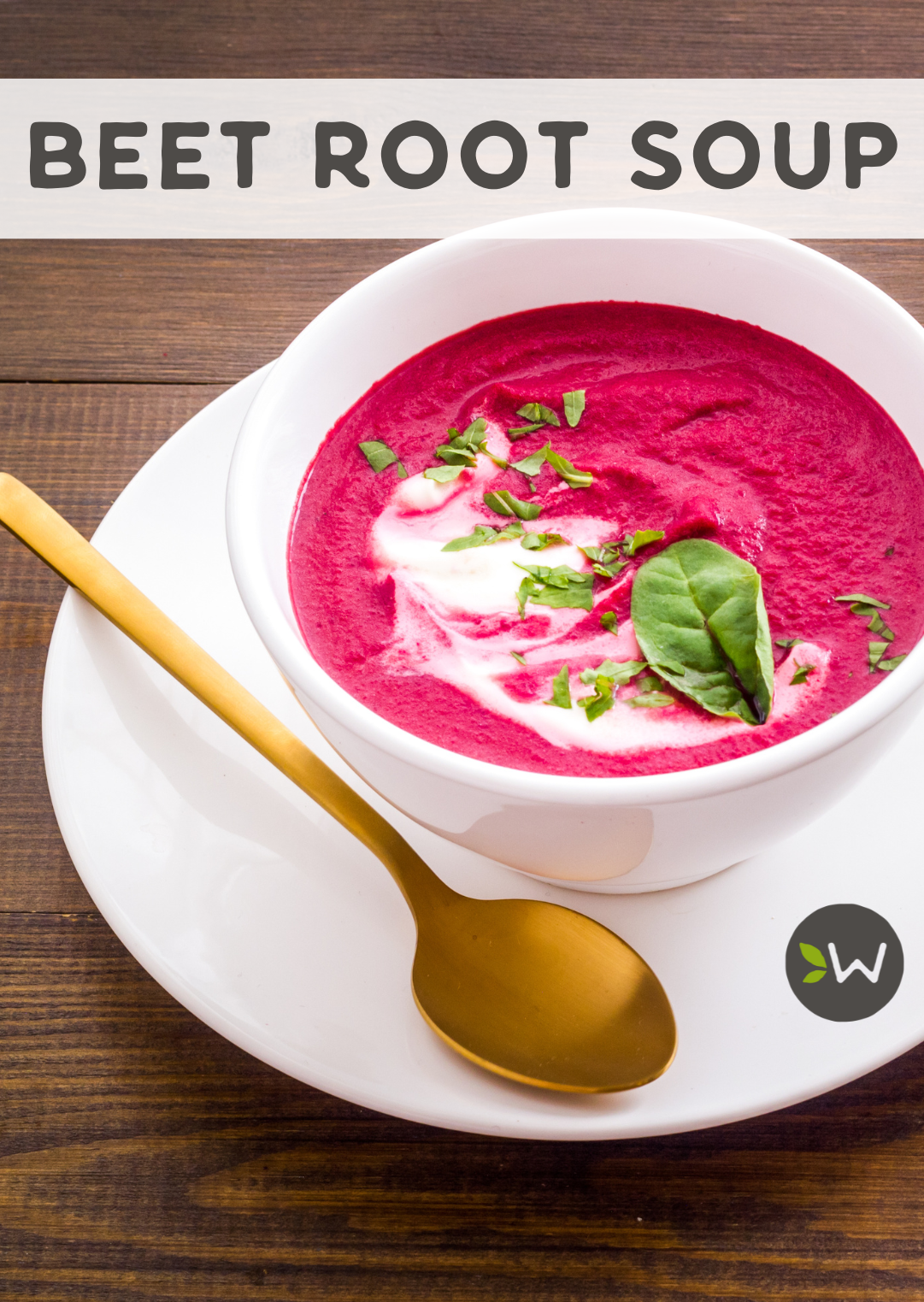 Photo of a bowl of bright beetroot soup in a white bowl on a white plate with a gold spoon sitting on a dark brown rough wood table.