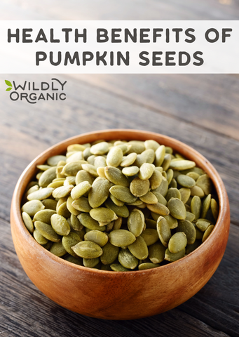 Side image of a wood bowl of shelled raw pumpkins on a wood table and Health Benefits of Pumpkin Seeds text overlay.