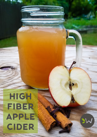 A jar of apple cider with a half-sliced apple and cinnamon sticks, labeled HIGH FIBER APPLE CIDER